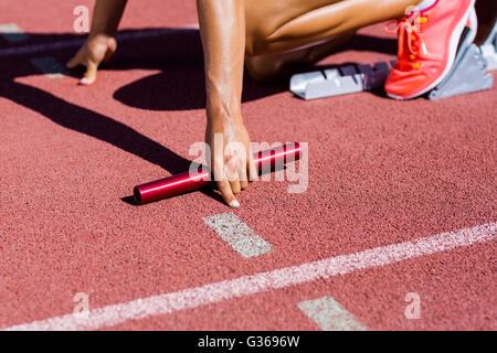 Athlète féminin prêt à commencer la course de relais Banque D'Images