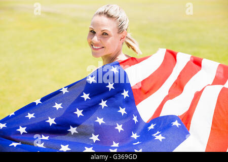 Portrait of happy female athlete holding up drapeau américain avec la médaille d'or Banque D'Images