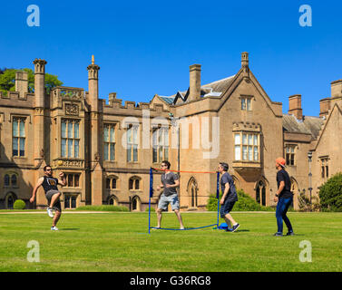 Un groupe de jeunes hommes jouant Sepak Takraw (kick volley-ball) sur la pelouse. à l'abbaye de Newstead, nottinghamsh Banque D'Images