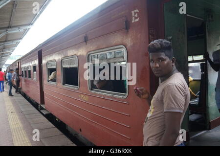 Un jeune homme sur la plate-forme de la gare de Kandy, Sri Lanka. Banque D'Images