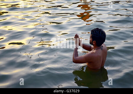 Jeune homme propose des prières au Soleil après avoir pris une immersion sainte, Kumbh Mela, Ujjain, Madhya Pradesh, Inde - 2016 Banque D'Images