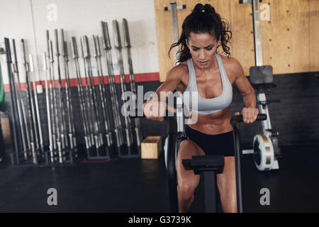 femme de fitness sur le vélo faisant de la spinning au gymnase. Fit jeune femme travaillant sur le vélo de gymnastique. Banque D'Images