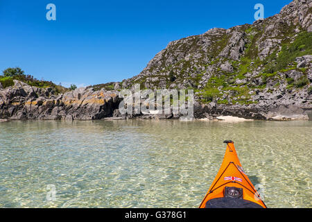 Le kayak de mer dans les eaux cristallines de la côte ouest de l'Écosse, dans la région de Moidart à Arisaig Banque D'Images