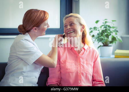 Infirmière peigner les cheveux de senior woman Banque D'Images