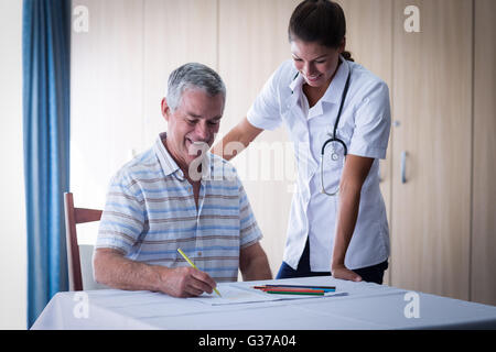 Aider un médecin senior man tout en appelant à l'élaboration d'adresses Banque D'Images