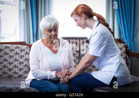 Femme médecin senior femme consolant dans la salle de séjour Banque D'Images