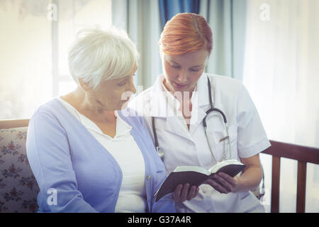 Médecin et patient de lire un livre Banque D'Images