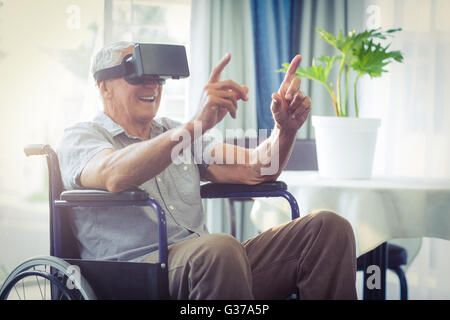 Happy senior man sur fauteuil roulant à l'aide de casque VR Banque D'Images