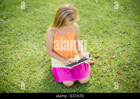 Young Girl using digital tablet in park Banque D'Images