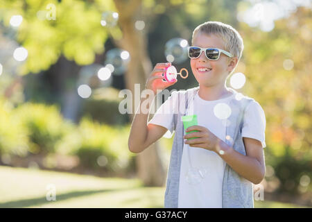 Young boy blowing bubbles par bubble wand Banque D'Images