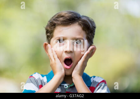 Jeune garçon faisant l'expression de surprise tout en tirant funny faces Banque D'Images