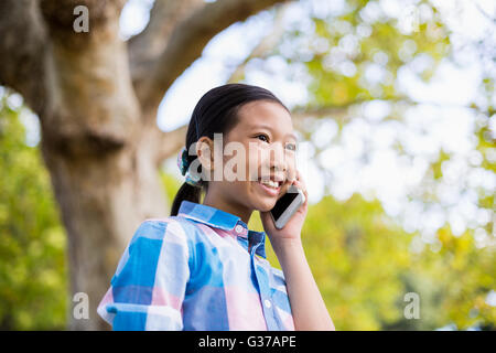 Smiling girl talking on mobile phone Banque D'Images