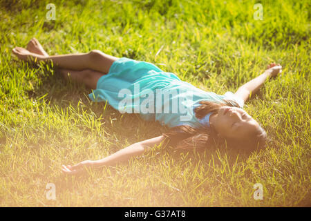 Cute young girl lying on grass in park Banque D'Images