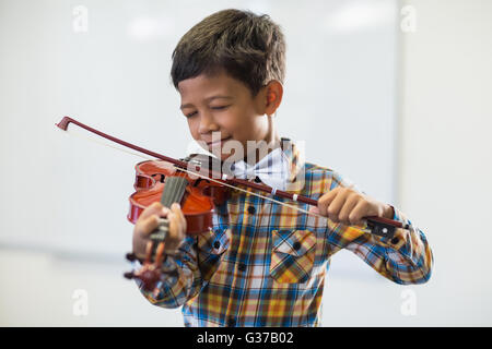 Écolier à jouer du violon en classe Banque D'Images