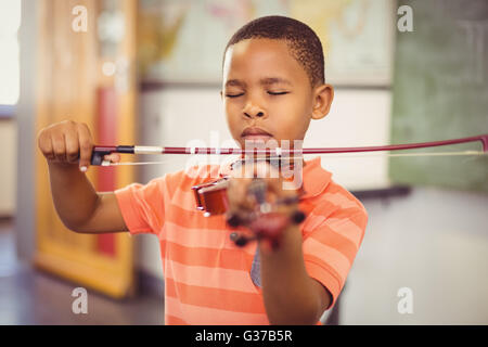 Écolier à jouer du violon en classe Banque D'Images