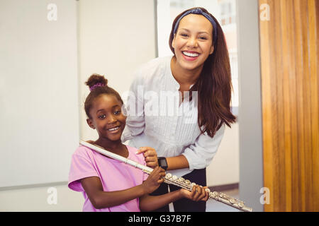 Portrait d'enseignant et fille avec flûte en classe Banque D'Images