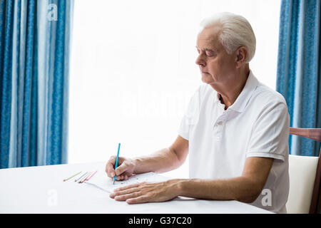Man en utilisant un livre de coloriage Banque D'Images