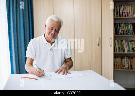 Man en utilisant un livre de coloriage Banque D'Images