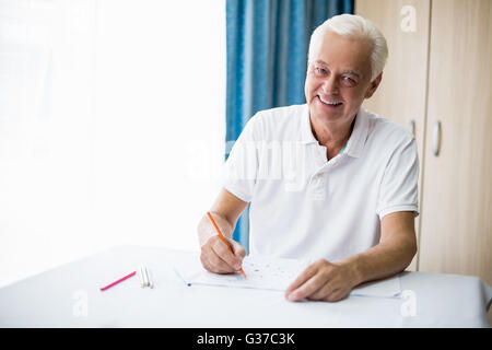 Man en utilisant un livre de coloriage Banque D'Images