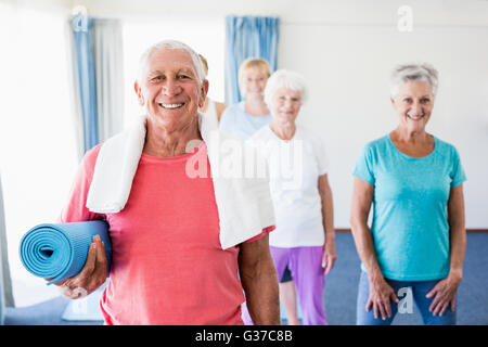 Senior man holding yoga mat Banque D'Images