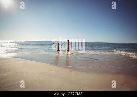 Couple running on beach Banque D'Images
