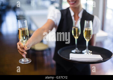 Section intermédiaire de serveuse offrant un verre de champagne Banque D'Images