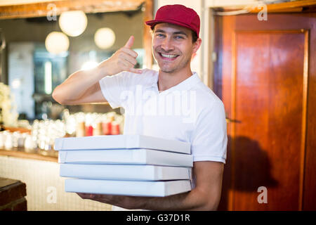Pizza delivery man holding boîtes à pizza faire un geste Banque D'Images