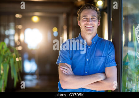 Portrait of smiling man standing with arms crossed Banque D'Images