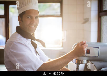 Portrait of chef mélange la pâte en mélangeant le mélangeur Banque D'Images