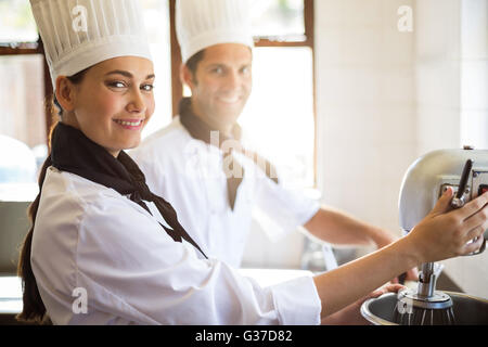 Portrait of chef mélange la pâte en mélangeant le mélangeur Banque D'Images