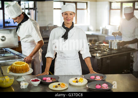 Portrait de femme chef presenting dessert plates Banque D'Images