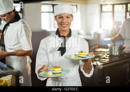 Portrait de chef presenting dessert plates Banque D'Images