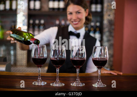 Portrait de bartender pouring un vin rouge dans le verre Banque D'Images