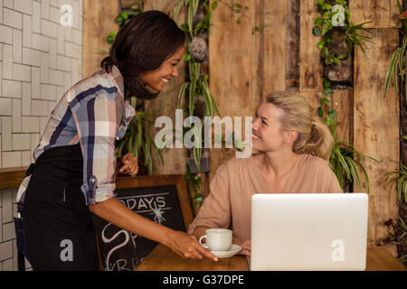Waitress serving un café à un client Banque D'Images