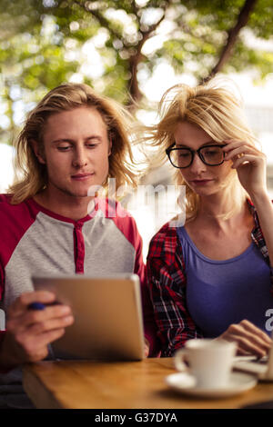 Couple à l'aide d'un ordinateur tablette sur une terrasse extérieure Banque D'Images