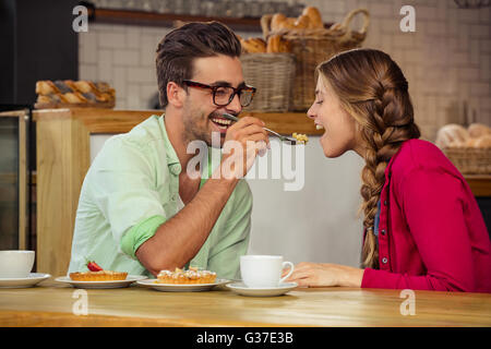 Smiling couple eating cake Banque D'Images