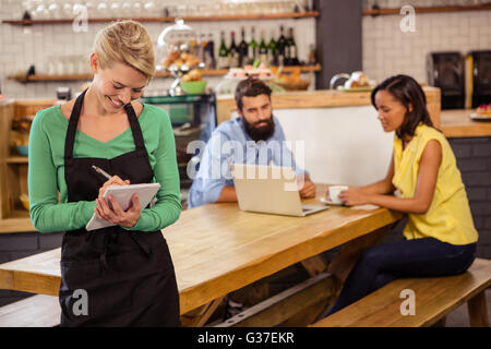 Waitress sur un PC portable. Banque D'Images