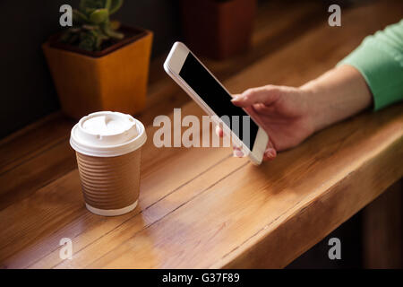 L'accent sur l'aide femme hipster smartphone avec verre Banque D'Images
