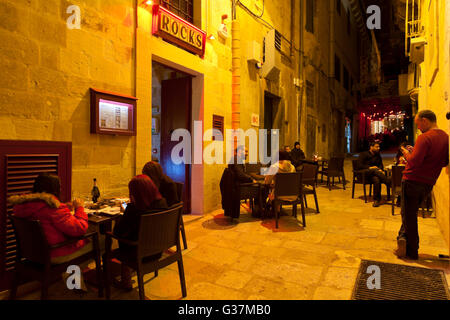 Des tables à l'extérieur d'un bar dans la rue du détroit de La Valette. Banque D'Images