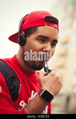 Portrait de garçon noir moderne à l'aide de e-cig vaporizer périphérique pour fumeurs de tabac liquide glycérine avec saveur. Gadget populaire chez les jeunes et qui veulent améliorer la santé et de cesser de fumer Banque D'Images