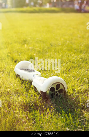 Mini électrique blanc hover board scooter on Green grass in park. Eco city transportation sur batterie, ne produisent pas de pollution de l'air à l'atmosphère Banque D'Images