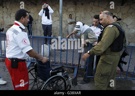 Bethléem, Cisjordanie, territoire palestinien. 10 Juin, 2016. Un homme palestinien en fauteuil roulant est aidé à un poste de contrôle israélien comme il fait son chemin pour assister à la première prière du vendredi du saint mois de jeûne du Ramadan à Jérusalem, mosquée al-Aqsa, dans la ville cisjordanienne de Bethléem le 10 juin 2016 : Crédit Hashlamoun Wisam APA/Images/ZUMA/Alamy Fil Live News Banque D'Images