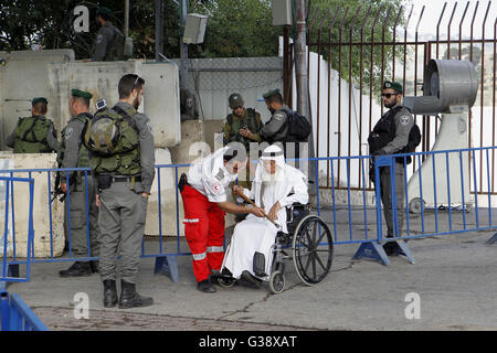 Bethléem, Cisjordanie, territoire palestinien. 10 Juin, 2016. Un homme palestinien en fauteuil roulant est aidé à un poste de contrôle israélien comme il fait son chemin pour assister à la première prière du vendredi du saint mois de jeûne du Ramadan à Jérusalem, mosquée al-Aqsa, dans la ville cisjordanienne de Bethléem le 10 juin 2016 : Crédit Hashlamoun Wisam APA/Images/ZUMA/Alamy Fil Live News Banque D'Images