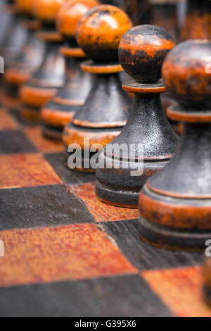 Les pions noirs en bois vintage pièces des échecs en ligne, l'accent sur la deuxième feuille Banque D'Images