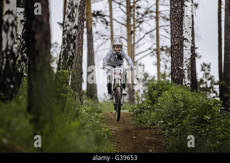 Fille du vélo de montagne sur des randonnées en vélo sur la voie dans la forêt durant 'La Coupe Ryder' downhill Banque D'Images