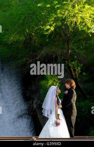 Une femme et un homme se regardant les uns les autres en se tenant debout en face d'une cascade. Banque D'Images