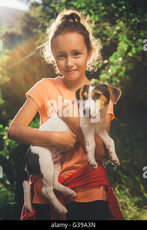 Girl holding un chien smiling and looking at camera Banque D'Images