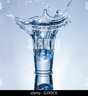 L'icecube projections dans un verre d'eau. Banque D'Images