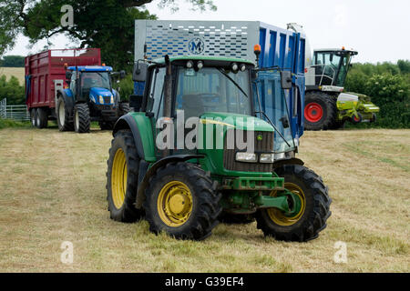 Les tracteurs dans un champ ensilage Banque D'Images