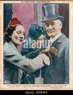 Le Premier ministre britannique Neville Chamberlain et son épouse en mars 1938, compte tenu des fleurs par un admirateur en gratitude pour son rétablissement Date : 1869 - 1940 Banque D'Images